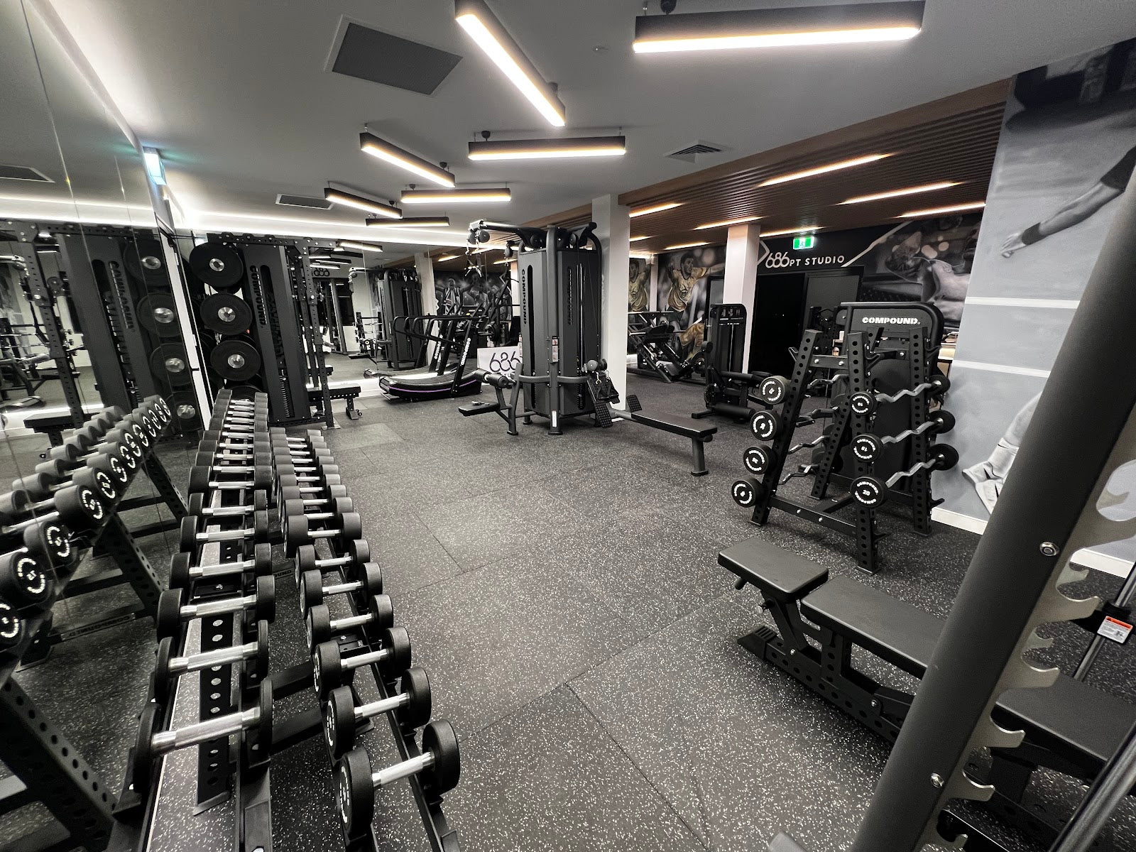 Full boutique PT studio floor with dumbbells and racks by Compound Fitness