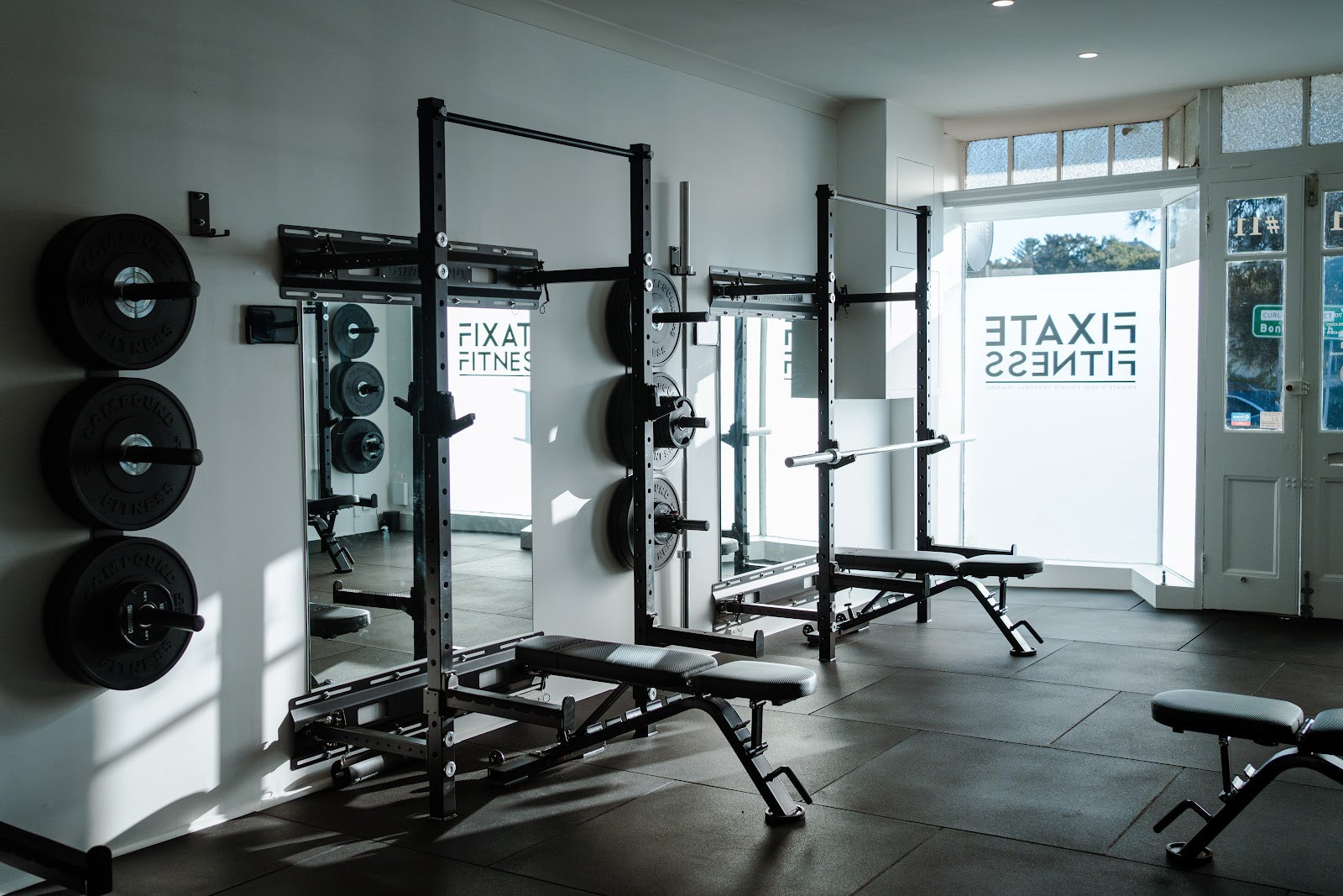 Bright boutique studio entrance with racks and mirrors by Compound Fitness