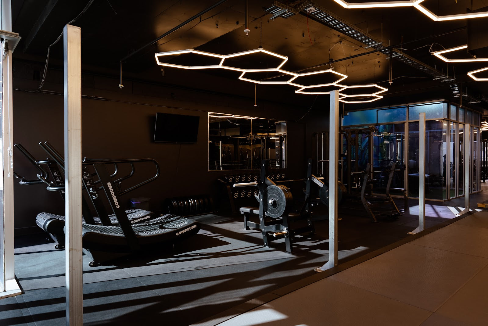 Boutique studio with hex lighting, cardio and glass-walled floor by Compound Fitness