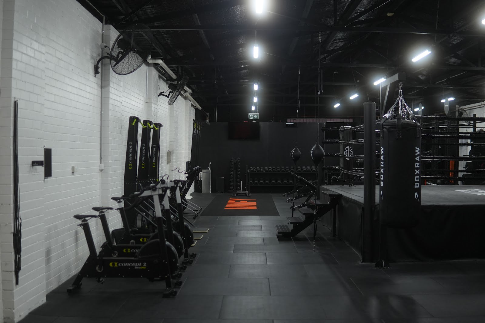 Boutique gym floor with cardio, racks and boxing ring by Compound Fitness