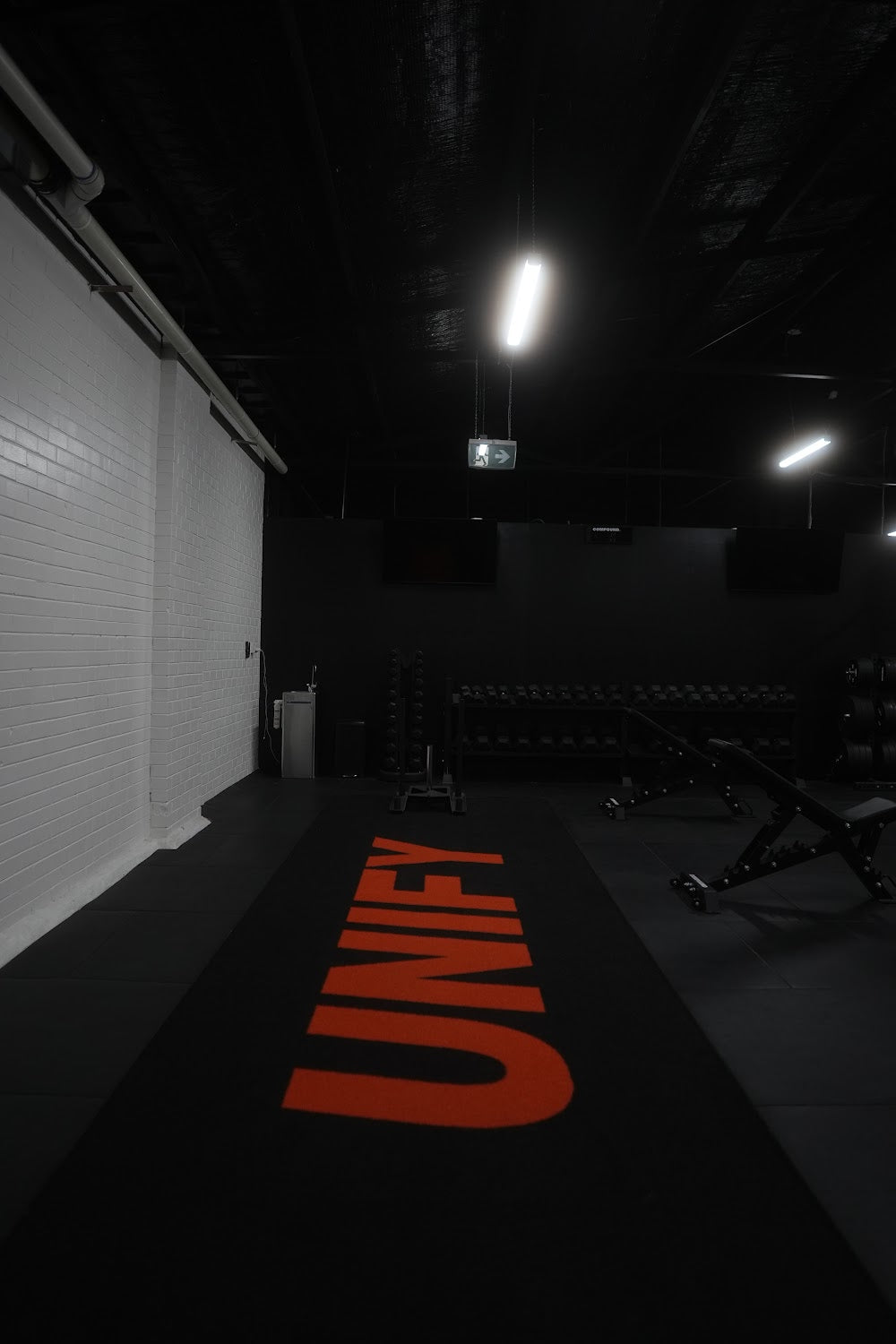 Deep view across a boutique gym training floor by Compound Fitness