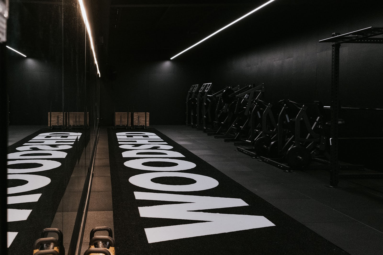 Branded turf and machine row in a boutique gym fitout by Compound Fitness