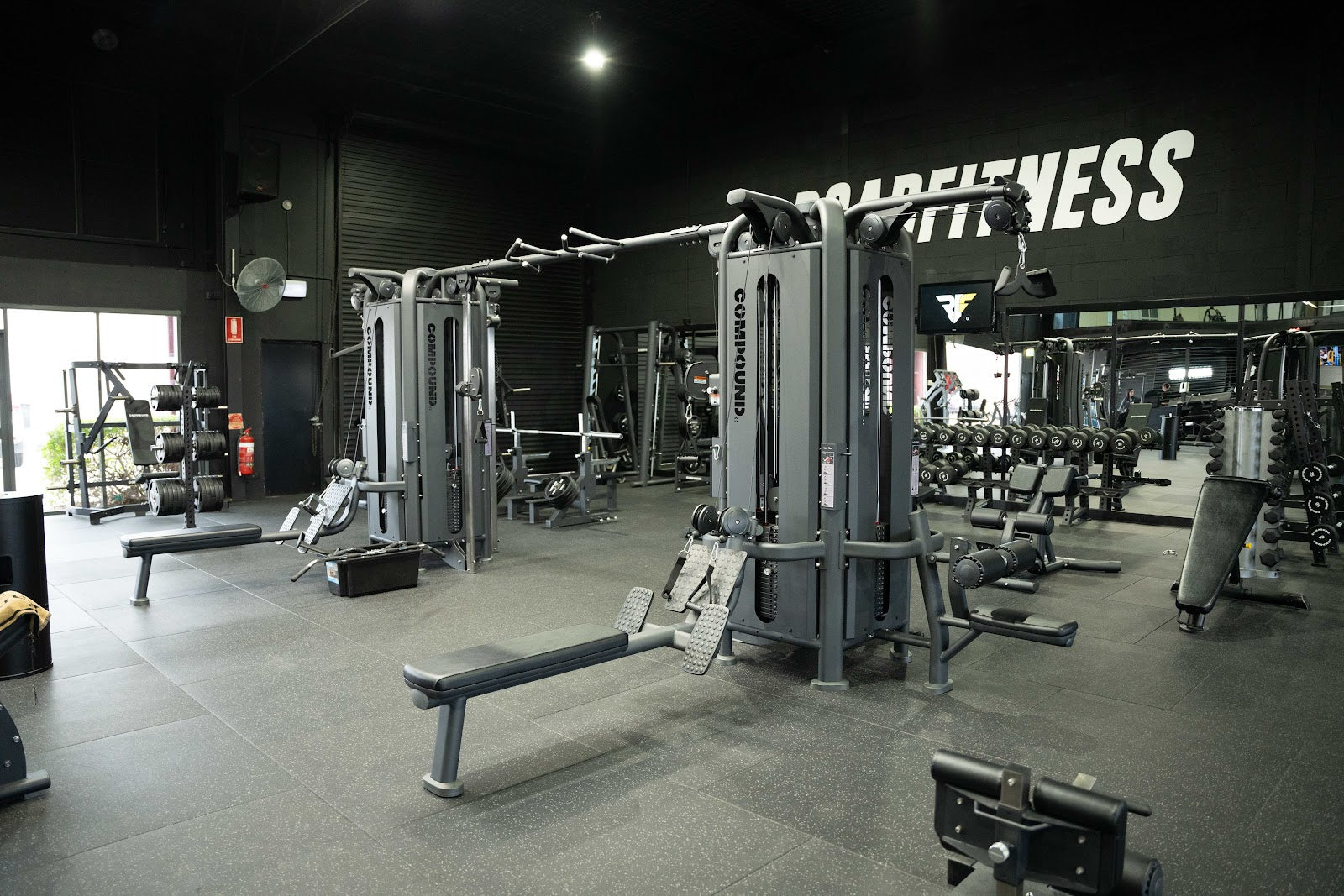 Multi-station cable rig and open training floor in a 24/7 gym by Compound Fitness