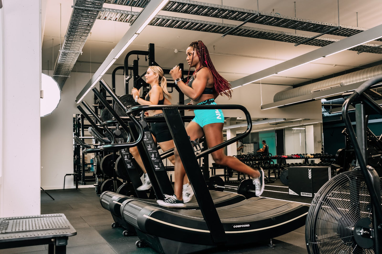 Members training on curved treadmills in a 24/7 gym fitout by Compound Fitness